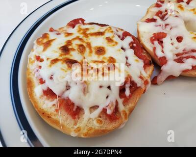 Nahaufnahme von zwei Pizzabagel-Hälften, die auf einem blau umrandenen Teller ruhen, aufgenommen in Lafayette, Kalifornien, 20. April 2021. () Stockfoto