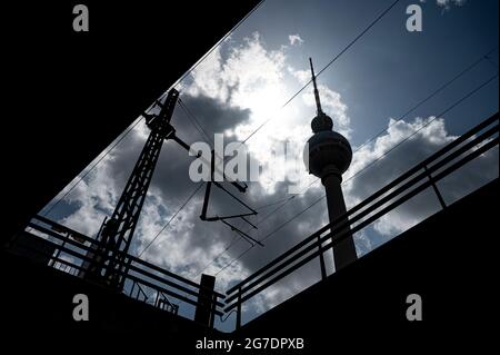 Berlin, Deutschland. Juli 2021. Die Sonne scheint durch die Wolken hinter dem Fernsehturm. Quelle: Fabian Sommer/dpa/Alamy Live News Stockfoto