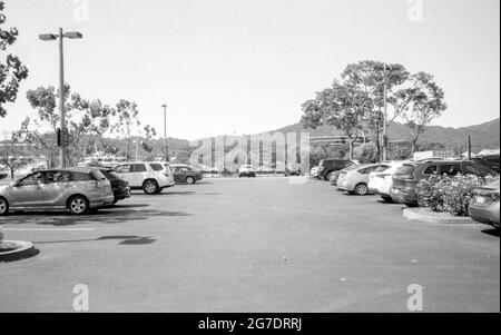 Schwarz-Weiß-Fotografie eines Parkplatzes mit geparkten Autos und Bergen im Hintergrund, Larkspur, Kalifornien, 15. August 2020. () Stockfoto