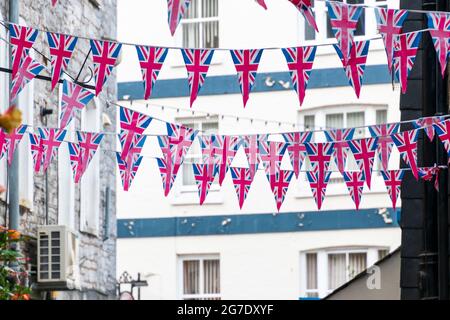 Die dreieckige Flagge von British Union Jack ist als Vorbereitung auf eine Straßenparty zu sehen. Festliche Dekorationen für Union Jack-Ammer. Stockfoto