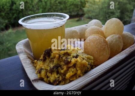 Leckere indische Snacks Pani puri mit Chat Masala Wasser und Zwiebeln in Scheiben geschnitten. Traditionelles indisches Snack-Gericht, auch bekannt als Wasserbälle, Golgappe, Puchka. Stockfoto