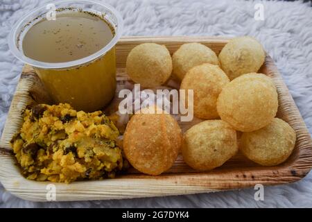 Leckere indische Snacks Pani puri mit Chat Masala Wasser und Zwiebeln in Scheiben geschnitten. Traditionelles indisches Snack-Gericht, auch bekannt als Wasserbälle, Golgappe, Puchka. Stockfoto