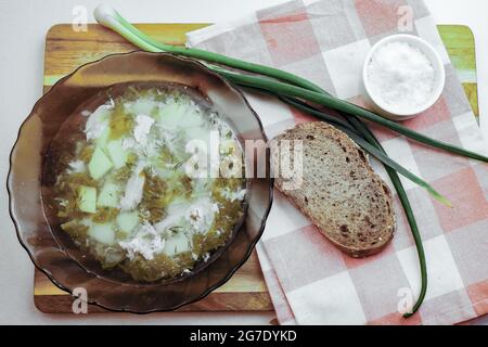 Suppe aus Sauerampfer, grünen Zwiebeln und Eiern wird auf einen Teller gegossen Stockfoto