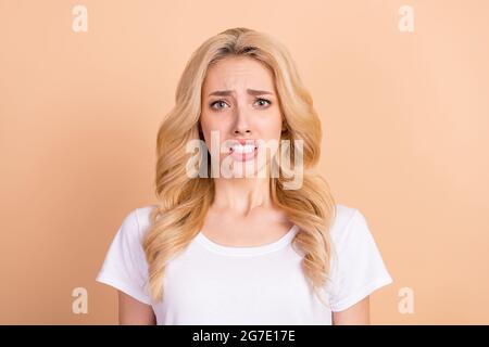 Foto Porträt blond Frau nervös Angst in casual Outfit isoliert pastellfarben beige Hintergrund Stockfoto