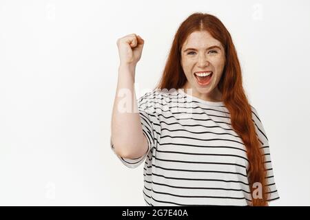 Go Team. Fröhliches junges Rotschopf-Mädchen, Aktivistin klatschen die Faust und Pumpen den Arm hoch, um zu singen, sich für jemanden zu wurzeln, für Menschenrechte und Einheit marschieren Stockfoto