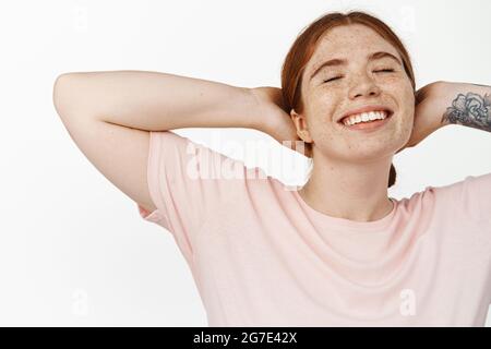 Nahaufnahme Porträt von unbeschwerten Ingwer-Mädchen ruhen, liegen mit den Händen hinter dem Kopf, ruhen frei und glücklich Pose, schließen die Augen, Tagträumen beim Entspannen Stockfoto