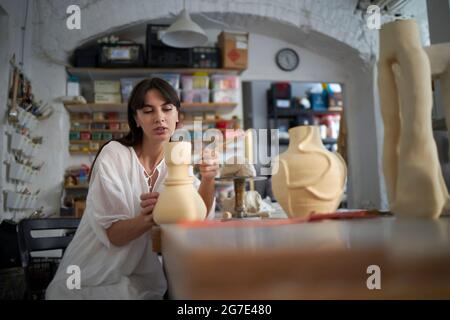 Eine Frau, die ihre Skulpturen in ihrem künstlerischen Atelier macht Stockfoto