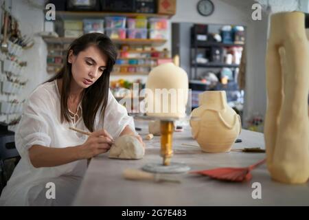 Eine Künstlerin, die ihre Töpferei in ihrem Atelier herstellt Stockfoto