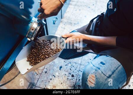 Frau nimmt Kaffeebohnen aus dem Lager, um sie zu verkaufen Stockfoto