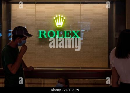 Die Menschen sahen sich in Hongkong vor dem Schweizer Luxusuhrmacher Rolex-Logo anstehen. Stockfoto