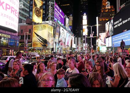 Touristen treffen sich nachts am Times Square, Manhattan, New York City. Stockfoto