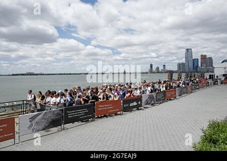 Touristen standen Schlange, um die Statue Cruises zu besteigen, um die Liberty Satue in New York City zu besuchen. Stockfoto