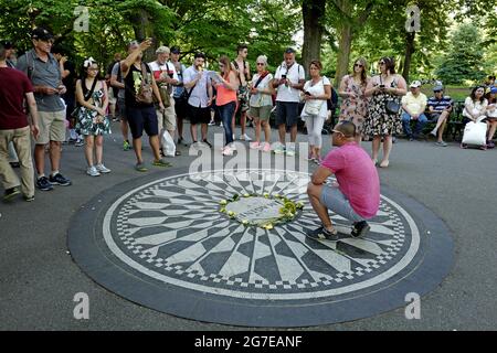 Touristen zollen John Lennon am Strawberry Fields Memorial im Central Park in New York City Tribut. Stockfoto