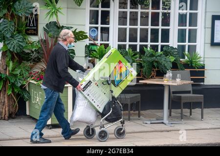Windsor, Großbritannien. Juli 2021. Ein Mann schiebt einen fernseher und Bettwäsche auf einen Spaziergänger. Windsor war heute mit Einkäufern beschäftigt. Quelle: Maureen McLean/Alamy Live News Stockfoto