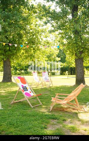 POZNAN, POLEN - 19. Jul 2017: Die Holzstühle eines Restaurants stehen auf grünem Gras im Jan Pawla Park Stockfoto