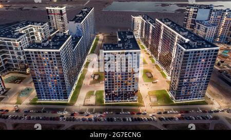 Beleuchtetes modernes Wohngebiet mit geparkten Autos in der Nacht. Hochwinkelige Luftaufnahme Stockfoto