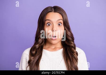 Porträt der jungen schönen schockiert überrascht überrascht Mädchen unerwartete Nachrichten auf violettem Hintergrund isoliert hören Stockfoto