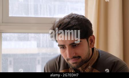 Nahaufnahme eines Indianers in einer Lederjacke, der vor den Fenstern sitzt Stockfoto