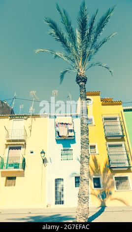 Im Retro-Stil gehaltene, verblasste Bilderreihe mit pastellfarbenen Terrassen, traditionellen mediterranen Häusern mit Palmen, La Vila Joiosa, Alicante Spanien Stockfoto