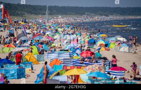 Zinnowitz, Deutschland. Juli 2021. Strandgänger haben sich am Strand der Ostsee bei Temperaturen von fast 30 Grad versammelt. Viele Touristen genießen Sonne, Sand, Wellen und Meer am Strand auf der Insel Usedom. Quelle: Stefan Sauer/dpa/Alamy Live News Stockfoto