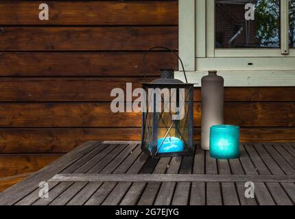 Dekorative Laterne aus Metall mit blauen Canles, die auf einem Holztisch leuchten, Vintage-Design mit Kopiefläche Stockfoto