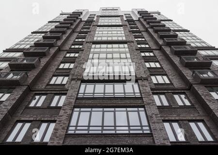 Neues Hochhaus am Himmel. Stadtlandschaft. Urbanisierung. Low-Angle-Aufnahme einer neu errichteten Hochhauswohnung Stockfoto