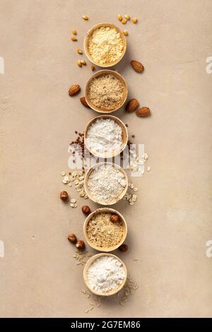 Verschiedene glutenfreie Mehl (Mandelmehl, Haferflockenmehl, Buchweizenmehl, Reismehl, Maismehl) Draufsicht, flaches Lay Stockfoto