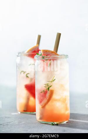 Trendige Sommergetränke mit Grapefruit und Rosmarin aus nächster Nähe. Erfrischende hausgemachte Cocktails, Sommergetränke, selektiver Fokus. Sonnige Schatten am Tag Stockfoto