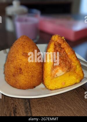 Traditionelle Street Food aus Sicilia, Taormina, Arancini Siciliani. Frittierte Risotto-Reisbällchen, gefüllt mit Fleisch-Ragu. Stockfoto