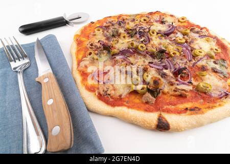 High-Angle-Weitwinkelaufnahme von frisch gebackener Pizza al tonno isoliert auf weißem Hintergrund. Thunfisch, Oliven, Zwiebeln, Gemüse, Kruste, Tomatensauce. Immer noch li Stockfoto