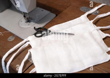 Nähen von medizinischen Schutzmasken mit eigenen Händen auf einer Nähmaschine, Mangel und Mangel an persönlicher Schutzausrüstung Stockfoto