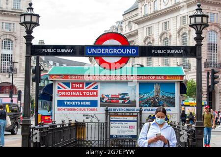 London, Großbritannien. Juli 2021. Eine Frau verlässt die U-Bahnstation Piccadilly Circus mit einer Gesichtsmaske.das obligatorische Tragen von Gesichtsmasken in den öffentlichen Verkehrsmitteln in England endet am 19. Juli ‘Dubber Freedom day', nachdem Boris Johnson bestätigt hat, dass die meisten obligatorischen Covid-19-Beschränkungen enden werden. (Photo by Dave Rushen/SOPA Images/Sipa USA) Quelle: SIPA USA/Alamy Live News Stockfoto