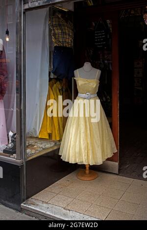 Gelbes Vintage-Kleid in der Tür des Vintage-Bekleidungsladens Armstrongs in der Clerk Street, Newington, Edinburgh, Schottland, Großbritannien. Stockfoto