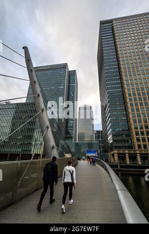 Die South Quay Footbridge, die South Dock im Bereich Canary Wharf der Londoner Docklands überquert. Menschen, die die Brücke von South Quay nach Canary Wharf überqueren Stockfoto