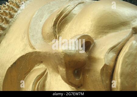 Das Gesicht einer liegenden Buddha-Statue in einem Tempel in Luang Prabang, Laos Stockfoto