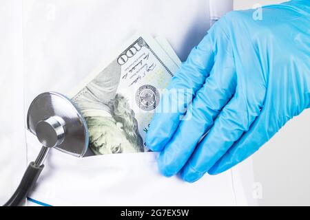 Ärztin nahm Geld. Das Korruptionskonzept. Doktor Hand mit Geld. Doktor legte Geld in seine Tasche. Stockfoto