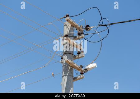 Ein Hochspannungsmast und verwickelte elektrische Kabel Stockfoto