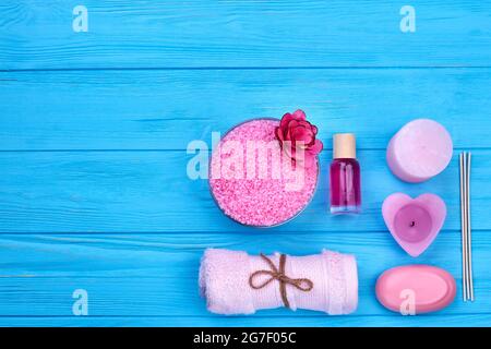 Flache pinke Accessoires für Bad und Spa auf blauem Holz. Stockfoto