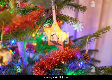 Handgefertigter Keramik-Sternenanhänger, der an einem echten Weihnachtsbaum hängt Stockfoto