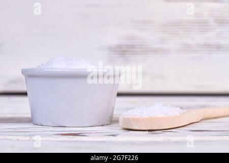 Haufen von weißem Salz mit rustikalem Holzlöffel. Stockfoto