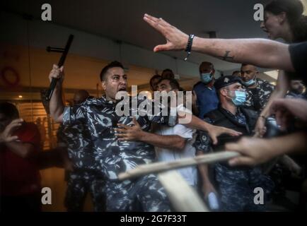 Beirut, Libanon. Juli 2021. Ein Polizist rastert mit Familien und Verwandten der Opfer der Hafenexplosion in Beirut am 04. August vor dem Haus des Hausmeisters des Innenministers Mohammad Fahmi während eines Protestes, der die Aufhebung der Immunität für drei Abgeordnete fordert, Hochrangige Politiker und Sicherheitschefs in dem zu untersuchenden Fall im Zusammenhang mit der Hafenexplosion in Beirut. Quelle: Marwan Naamani/dpa/Alamy Live News Stockfoto