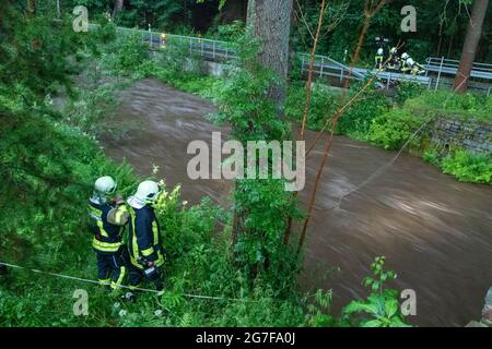 13. Juli 2021, Sachsen, Jöhstadt: Feuerwehrleute suchen am Steinbach nach einer Vermissten. Eine Sturmflut hatte einen Menschen während eines Sturms im sächsischen Jöhstadt (Erzgebirgsreis) weggefegt. (To dpa 'Sturm in Sachsen: Sturzflut nimmt den Menschen mit') Foto: Andre März/dpa-Zentralbild/dpa Stockfoto