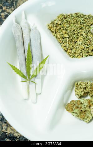 Draufsicht auf Tablett mit rauchfertigen Marihuanagelenken und Cannabisknospen. Nahaufnahme. Stockfoto