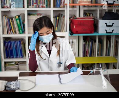 Nahaufnahme einer südostasiatischen Ärztin, die ihre Dokumente ansieht Stockfoto