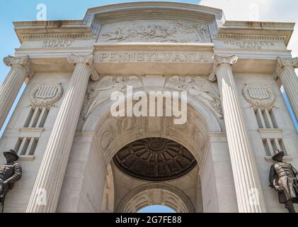 Gettysburg, PA, USA - 14. Juni 2008: Schlachtfelddenkmäler. Schauen Sie hoch zum weißen Pennsylvania State Memorial mit blauer Wolkenlandschaft am anderen Ende. Statuen von Stockfoto