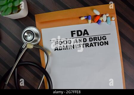 FDA - Food and Drug Administration Text im Dokument oben braunen Umschlag und Stethoskop. Healthcare oder medizinisches Konzept Stockfoto