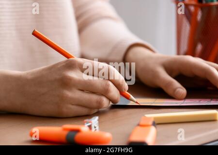 Frau Färbung Lesezeichen am Tisch, Nahaufnahme Stockfoto