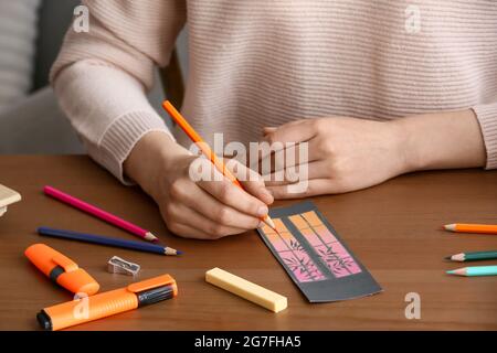 Frau Färbung Lesezeichen am Tisch, Nahaufnahme Stockfoto