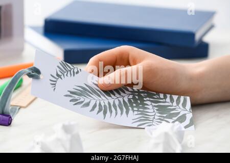 Frau mit Lesezeichen am Tisch, Nahaufnahme Stockfoto