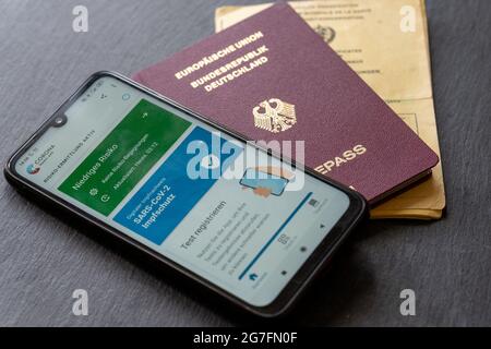 BERLIN, DEUTSCHLAND - 03. Jul 2021: Nahaufnahme eines deutschen digitalen grünen Passes in der Nähe eines deutschen Passes und einer Impfkarte Stockfoto